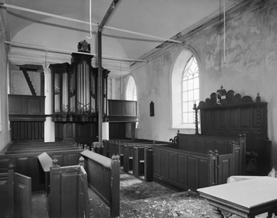 Interieur van de kerk voor de verbouwing, met rechts de herenbank en links achter het orgel.